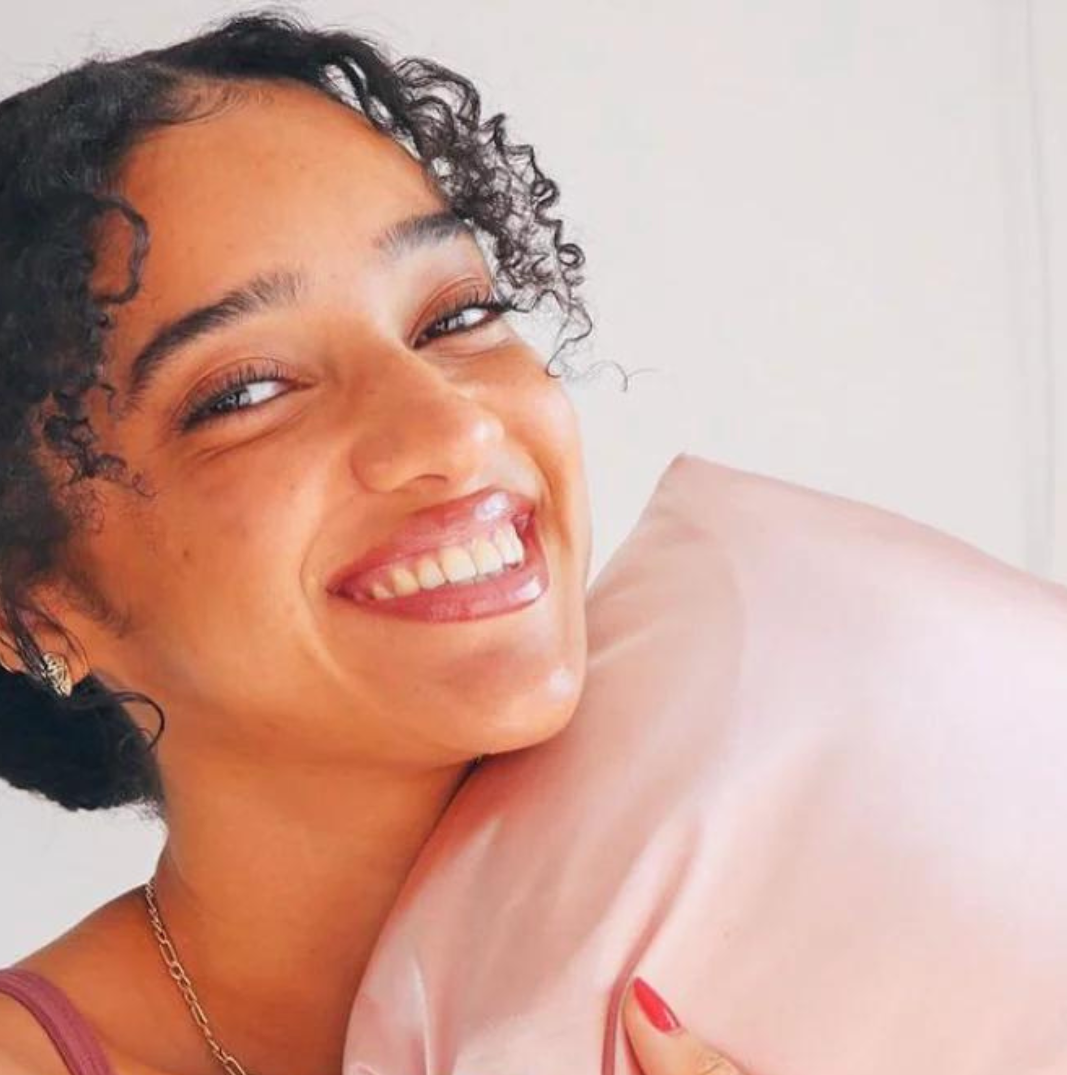 curly haired woman with pink satin pillowcases Osocurly